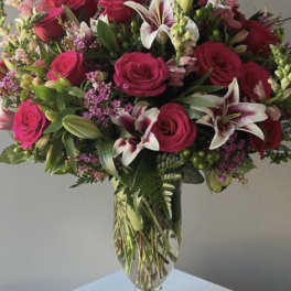 Bouquet of pink roses and lilies in a clear glass vase