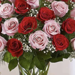 Bouquet of red and pink roses in a clear glass vase