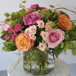 Mixed pink and orange roses in a clear glass vase