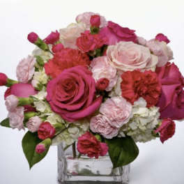 Pink and white roses with carnations in a clear glass vase