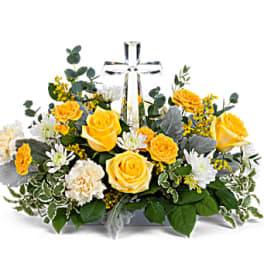Yellow and white floral arrangement with a clear glass cross centerpiece