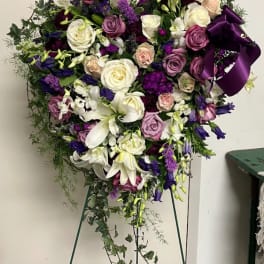 Large purple, white, and pink floral standing spray on an easel