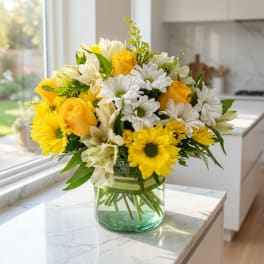 Yellow roses and white daisies in a glass vase