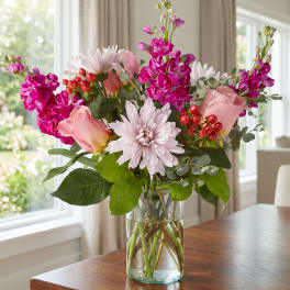 Bouquet of pink roses and chrysanthemums in a clear glass vase