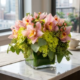 Pink orchids and green hydrangeas in a glass vase