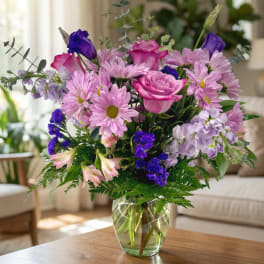 Pink and purple mixed bouquet in a clear glass vase