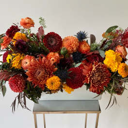 Large autumn flower arrangement in a white rectangular container