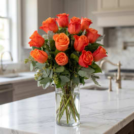 Orange rose bouquet in a clear glass vase