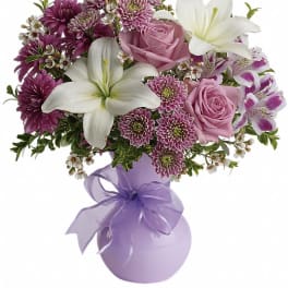 Pink and white bouquet with lilies, roses, and purple mums in a lavender vase
