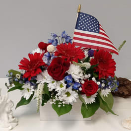 Red, white, and blue floral arrangement with an American flag