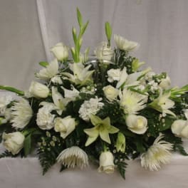 Low white floral centerpiece with roses, lilies, and chrysanthemums
