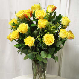 Yellow roses arranged in a clear glass vase