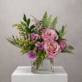 Pink and purple rose bouquet in a clear glass vase
