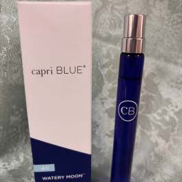 Blue perfume bottle beside a pink Capri Blue box