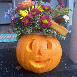 Jack-o'-lantern pumpkin with a colorful flower arrangement on top