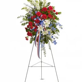 Standing floral spray with red, white, and blue flowers on an easel