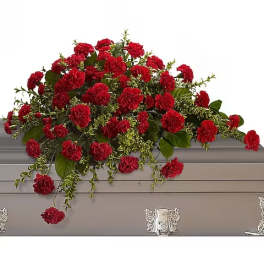 Red carnation spray on a gray casket