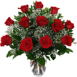 Bouquet of red roses with baby's breath in a clear glass vase