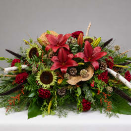 Large floral arrangement with red lilies, sunflowers, and red carnations