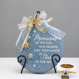 Blue memorial plaque with gold ribbon and star accents on a stand
