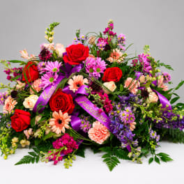 Large mixed bouquet with red roses, pink daisies, and purple flowers
