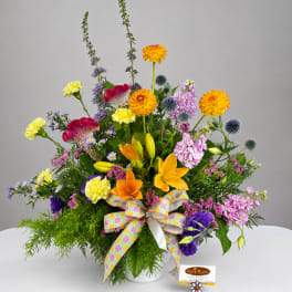 Colorful mixed bouquet in a white vase with a plaid ribbon