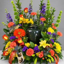 Colorful floral arrangement with a dark urn centerpiece and fish decoration