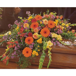 Colorful floral spray on a wooden casket