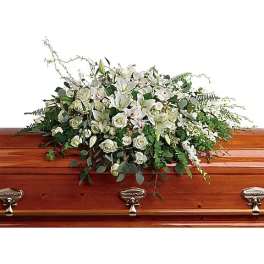 White floral spray on a wooden casket