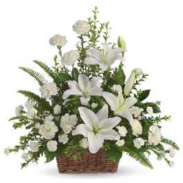 White lilies and carnations arranged in a wicker basket