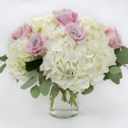 Pink roses and white hydrangeas in a clear glass vase