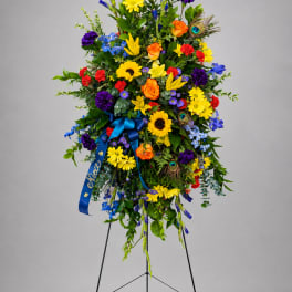 Tall standing floral spray with bright mixed flowers on a black easel