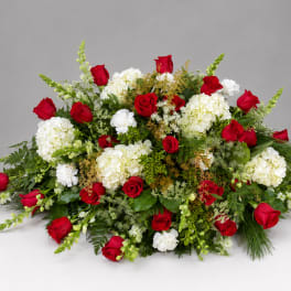 Red roses and white hydrangeas arranged in a low, wide spray