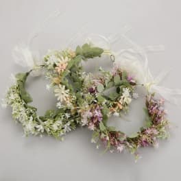 Two floral wreaths with white and pink blossoms tied with sheer ribbon