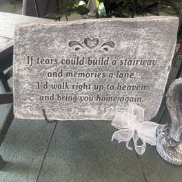 Memorial stone sign on a metal stand with a white ribbon bow