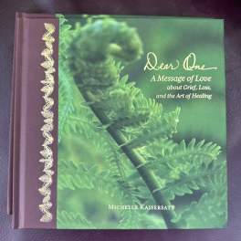 A purple hardcover book with a green plant cover and gold lettering.