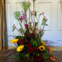 Tall mixed floral arrangement with red roses and yellow gerbera daisies