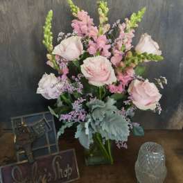 Pink roses and snapdragons arranged in a glass vase