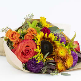 Bouquet of orange roses, sunflowers, and purple chrysanthemums wrapped in paper