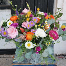 Colorful mixed bouquet in a speckled ceramic vase