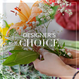 Hands arranging an orange lily with baby's breath