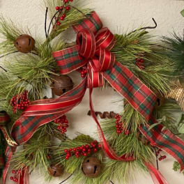 Holiday wreath with pine, red ribbon, berries, and bells