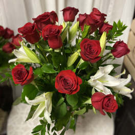 Bouquet of red roses and white lilies with green foliage