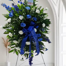 Large standing floral spray with blue and white flowers on an easel