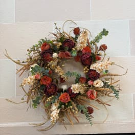 Autumn wreath with orange and burgundy roses on a circular base