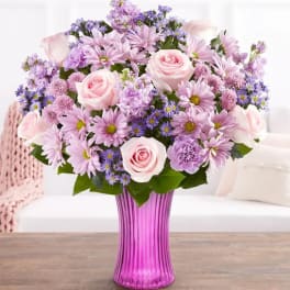 Pink and lavender bouquet in a purple glass vase
