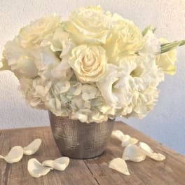 Cream rose and hydrangea arrangement in a textured silver vase