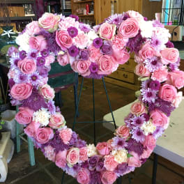 Heart-shaped floral wreath with pink roses and purple flowers