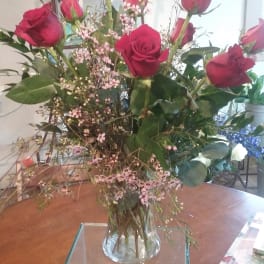 Tall bouquet of red roses in a clear glass vase