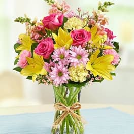 Bouquet of pink and yellow flowers in a clear glass vase